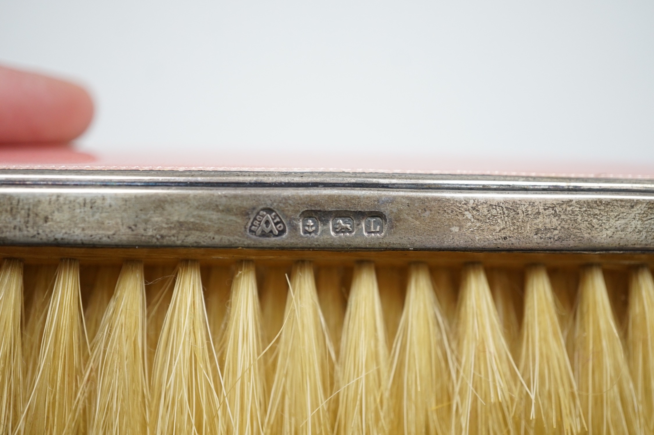 A George V five piece silver and pink guilloche enamel dressing table mirror and brush set, by Adie Brothers.